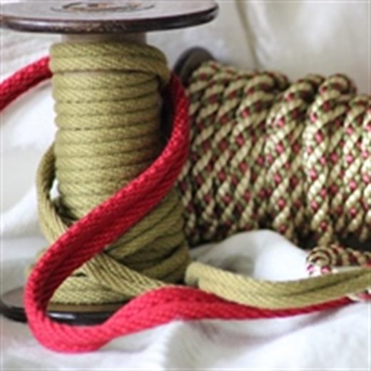 Spule mit grün-goldener Kordel und roter Schnur